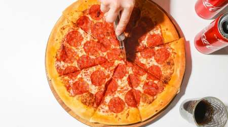 Pepperoni pizza being cut