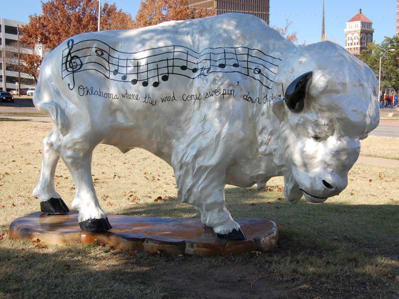White painted buffalo sculpture with music and lyrics from "Oklahoma"