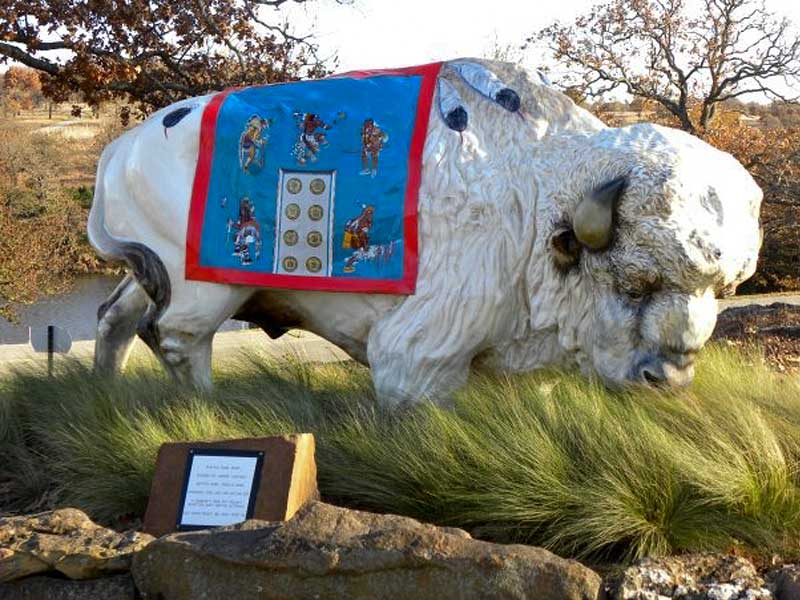 Magic White painted buffalo sculpture with painted blanket representing entrance to Woolaroc museum.